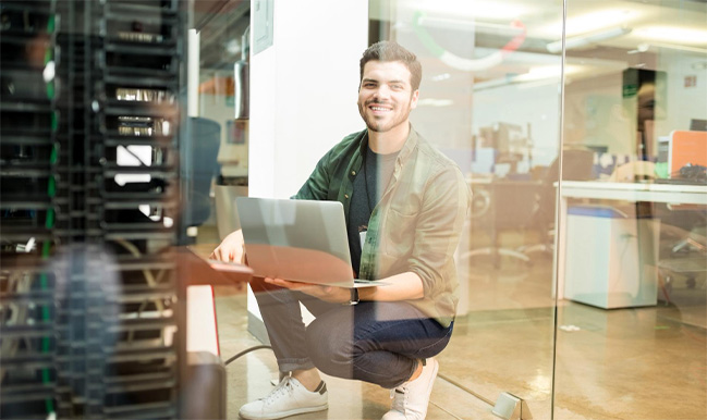 Man crouching on laptop